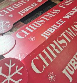 Handpainted Christmas Fair signs by Robotmother.  White writing on red painted wood, wtih some simply dingbat snowflakes